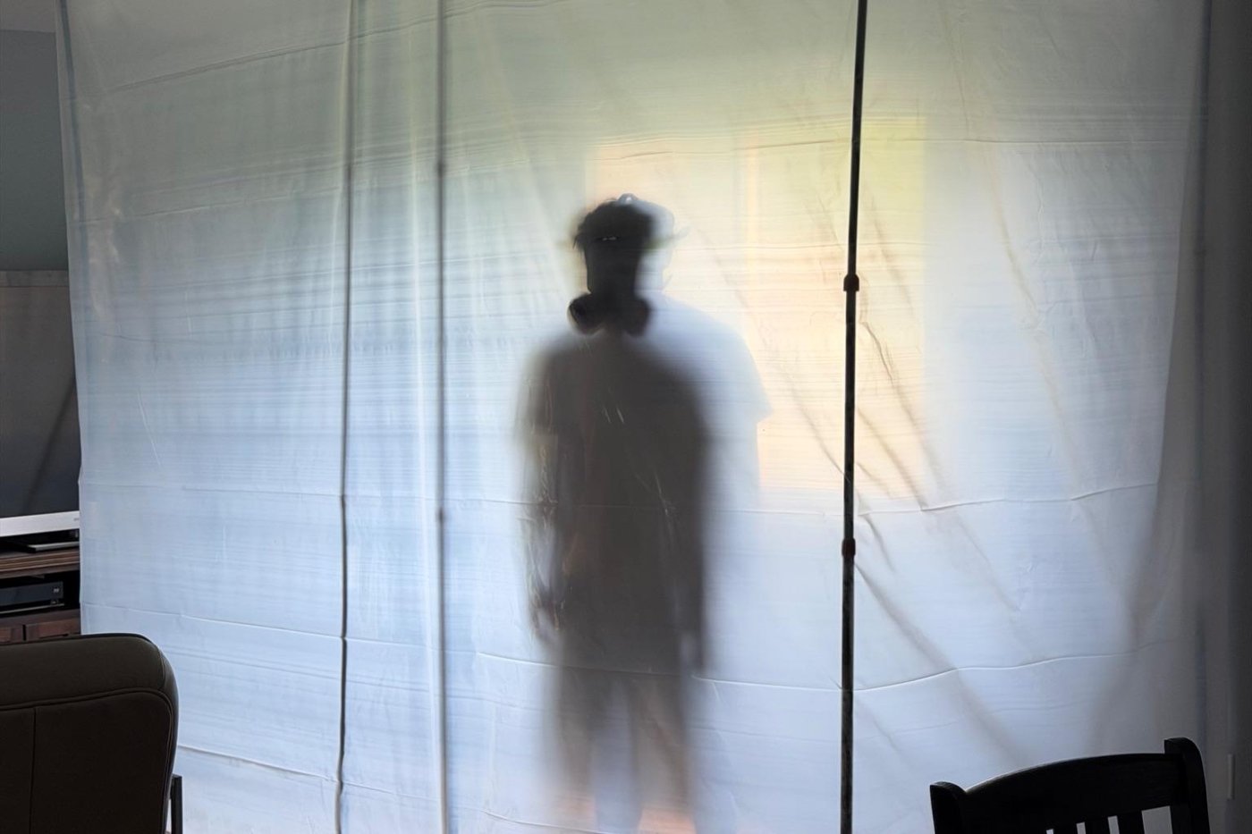Elliot Environmental technician working behind a sealed plastic containment barrier